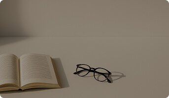 An open book and a pair of glasses lying on the table.